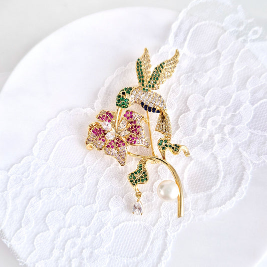 Goldene Brosche Kolibri, golden brooch, broche, spilla, Goldene Kolibri-Brosche mit Blume, bunten CZ-Steinen und weißer Perle – 18K vergoldetes Kupfer, romantisch-verspielter Schmuckstil